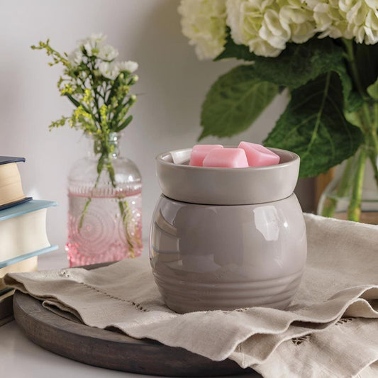 Gros plan sur la surface lisse et la silhouette moderne de la Lampe parfumée avec plaque chauffante ORB gris.