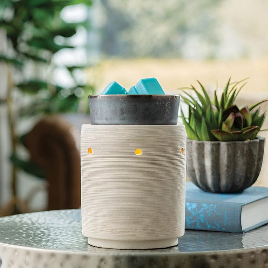 Lampe chauffe cire électrique Argile et Fer allumée, diffusant une lumière chaleureuse dans une décoration moderne.