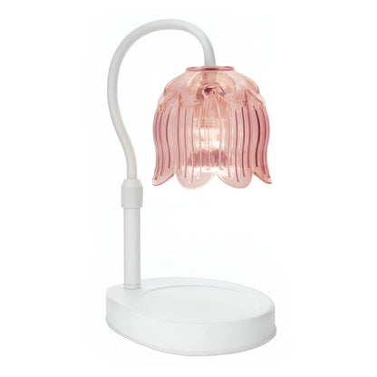 Lampe chauffe bougie électrique Tulipe Rose avec abat-jour en verre rose en forme de fleur et pied blanc.