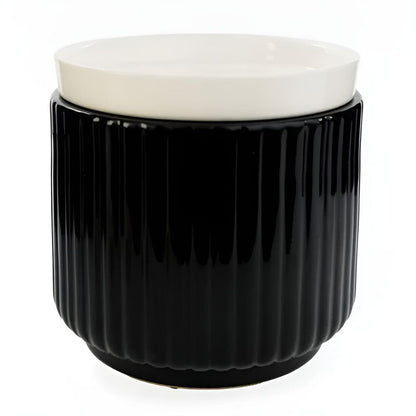 Photographie de studio sur fond blanc de la lampe à parfum électrique en céramique noire côtelée avec sa coupelle blanche amovible.