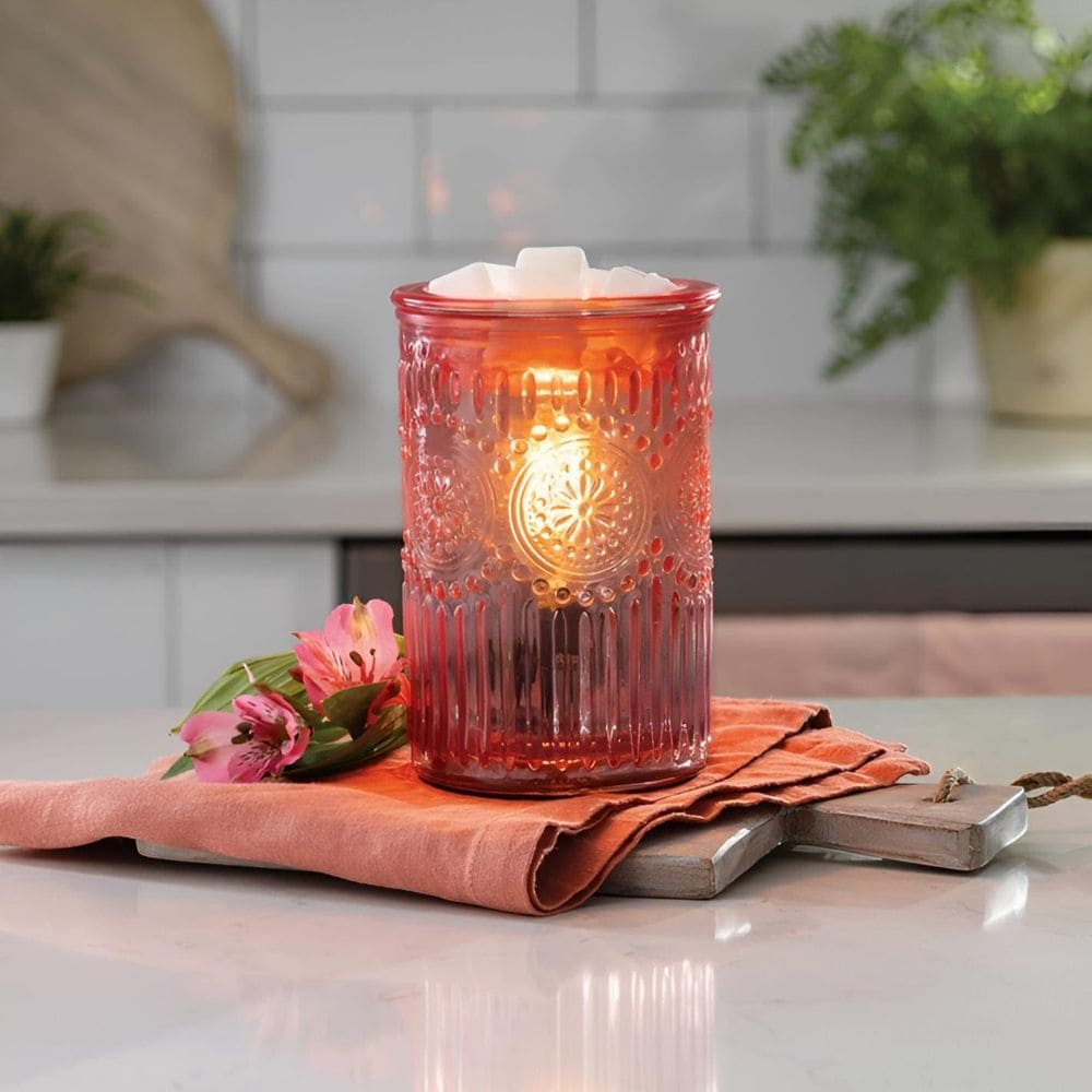 Lampe parfumée en verre rose travaillé dans un décor élégant.